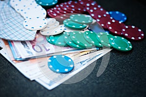 Casino poker chips stack with playing cards, dice and money on green felt background