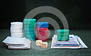 Casino poker chips stack with playing cards, dice and money on green felt background