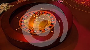 Casino roulette in motion with spinning wheel and ball. Winning number 33 and color red is determined by the roulette