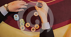 Hands of a young caucasian man playing poker in a casino. Close up of female hands with red cards.