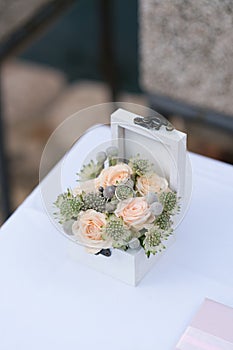 Casket with wedding rings and fresh flowers for ceremony