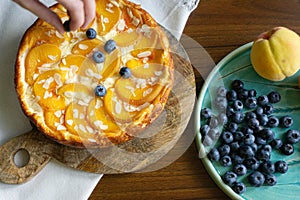 Casserole pie of cottage cheese with peaches. Ceramic plate with peaches and blueberries