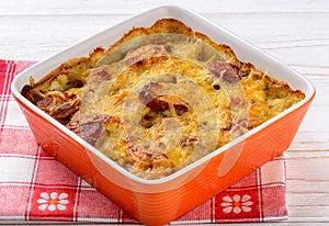 Casserole with potatoes, sausages, tomatoes and cheese.