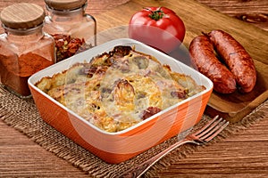 Casserole with potatoes, sausages, tomatoes and cheese.