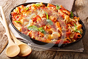Casserole ziti pasta with minced meat, tomatoes, herbs and cheese close-up. horizontal
