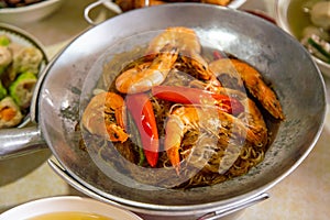 Casseroled prawns with Glass Noodels in Small Iron Pan with Fish, Fried Spring Rolls, Dim Sum, Seafood, Roasted Duck and Meatball