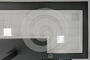 cassette stretched or suspended ceiling with square halogen spots lamps and drywall construction in empty room in house or office