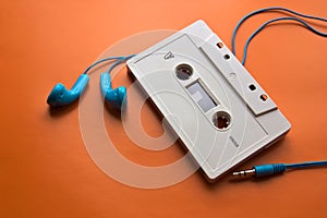 A cassette tape next to headphones for listening to music