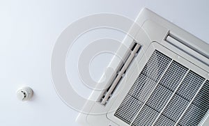 Cassette type air conditioner and smoke detector mounted on ceiling wall. Air duct on ceiling in hotel. Air heading unit on gypsum