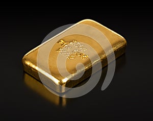 Cast gold bar, Stamped bullion bar, refined gold, front view over black photo