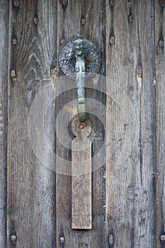 Cast iron or bronze door knocker on an old door.