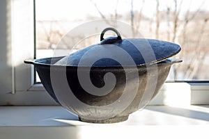 Cast iron cauldron on the windowsill