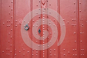 Cast iron door knocker and lock on an old door.