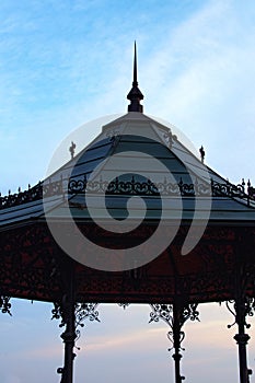Cast iron gazebo with dome roof supported by metal pillars. Blue sky in the background. Saint Volodymyr Hill.