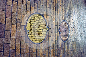 Cast-iron hatches on the sidewalk of brown brick