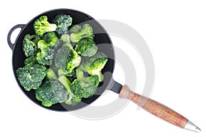 Cast iron pan with frozen broccoli for cooking