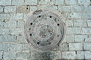 Cast-iron road hatch on stone road in Istanbul close up