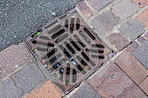 Cast-iron sewer grate on the sidewalk.