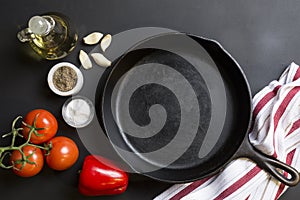 Cast Iron Skillet with copy area on black background with ingredients