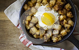 Cast iron skillet of eggs and home fry potatoes