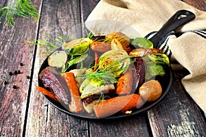 Skillet of roasted vegetables against rustic wood photo