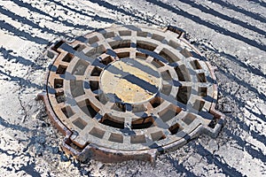 A cast-iron storm sewer hatch on the road before laying the asphalt pavement poured with bitumen. Drainage of rainwater from the