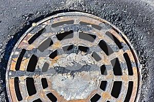 A cast-iron storm sewer hatch on the road before laying the asphalt pavement poured with bitumen. Drainage of rainwater from the