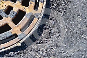 A cast-iron storm sewer hatch on the road before laying the asphalt pavement poured with bitumen. Drainage of rainwater from the