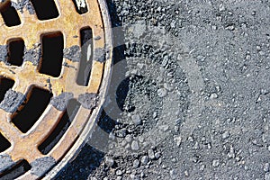 A cast-iron storm sewer hatch on the road before laying the asphalt pavement poured with bitumen. Drainage of rainwater from the