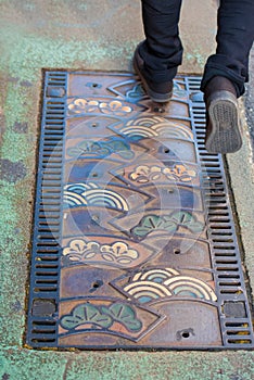 Cast metal hatch for urban drains, Odawara, Japan. Vertical.