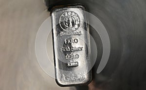 Cast silver bar weighing one kilogram on an abstract metal