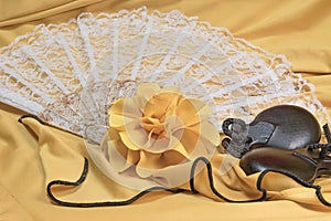 Castanets, yellow rose and white fan lying closeup
