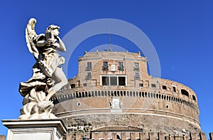 Castel SantAngelo and marble angel from bridge with blue sky. Rome, Italy.
