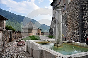 Castel thun, view of one of the towers and a fountain inside the castle walls