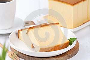 Castella kasutera - Beautiful delicious Japanese sliced sponge cake food on white plate over rustic white wooden table, close up