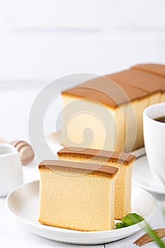 Castella kasutera - Beautiful delicious Japanese sliced sponge cake food on white plate over rustic white wooden table, close up