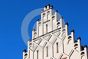 Castellation walls and turrets on a rooftop against the blue sky background