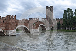 Castelvecchio bridge with castle tower against cloudy sky