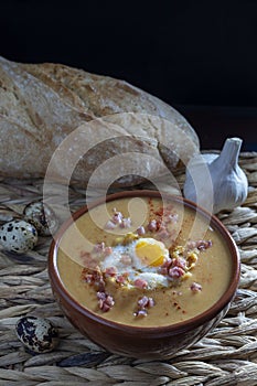 Castilian soups with garlic, bread, quail eggs and ham cubes