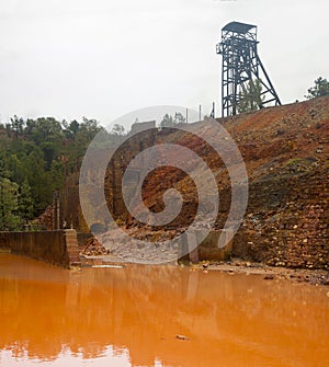 castillete of the Cerro del Hierro mine on a puddle with a characteristic orange color photo