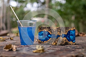 Casting blue epoxy resin burl wood cube on old table art background