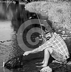 Casting that fish off. man with fish on rod. big game fishing. relax on nature. successful fisherman in lake water