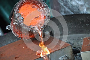 Casting liquid aluminium from crucible into sand form