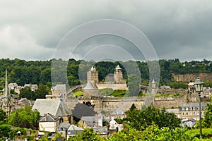 The castle dominating the old  town of FougÃ¨res under a dark sky