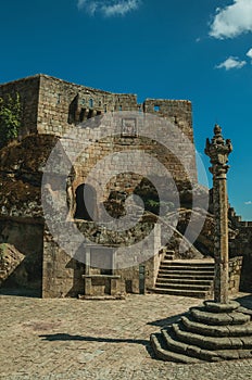 Castle facade over rocky hill on square with pillory