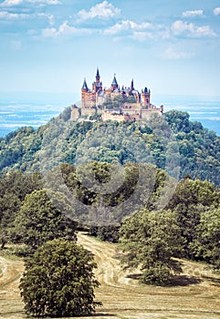 Castle Hohenzollern on top of wooded mountain, Baden-Wurttemberg, Germany. Famous Burg Hohenzollern is landmark in Swabia photo