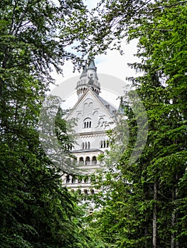 Castle of Neuschwanstein in Germany near Munich, Bavaria. Main tower trough trees.