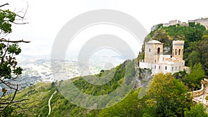 Castle of Pepoli at the top of the mountain, on the rocky cliff, with panoramic view, surrounded by green bushes and trees full o