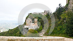 Castle of Pepoli at the top of the mountain, on the rocky cliff, with panoramic view, surrounded by green bushes and trees full o