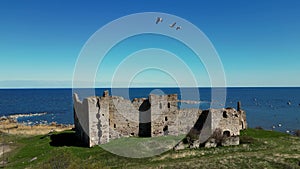 Castle in rural landscape Estonia. Beauty of Northern historic ruins by the sea